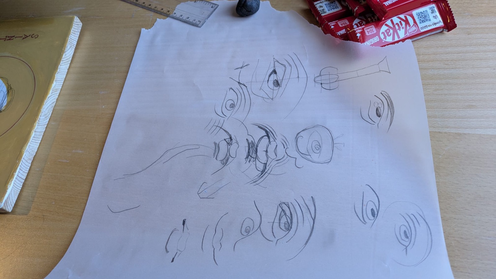 Pencil sketches of faces and eyes on a sheet of paper
